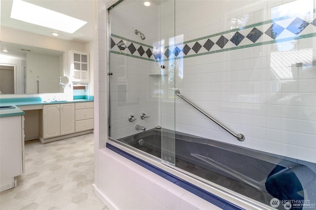 full bathroom with a skylight, tiled shower / bath, and vanity