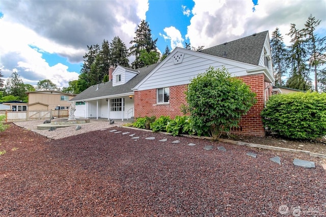 back of house with fence and brick siding