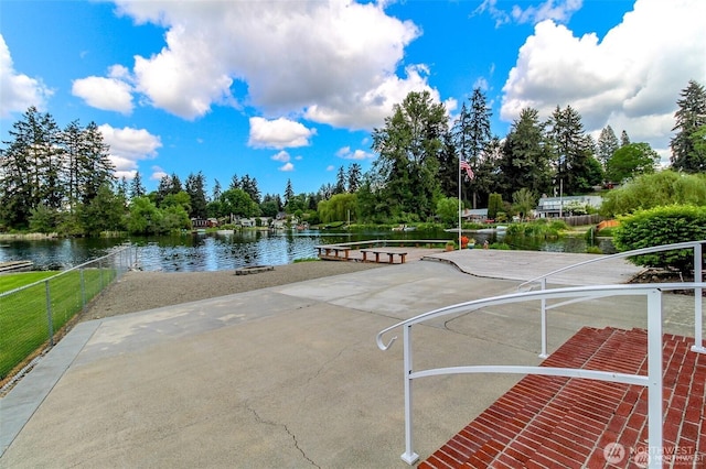 view of home's community with a water view and fence