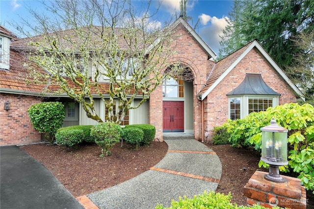 tudor-style house featuring brick siding