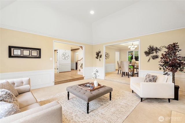 living area with stairway, a notable chandelier, wainscoting, and light carpet