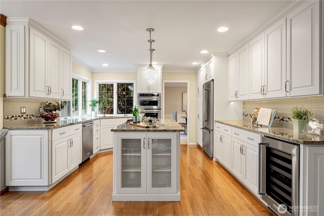 kitchen with wine cooler, appliances with stainless steel finishes, and white cabinets