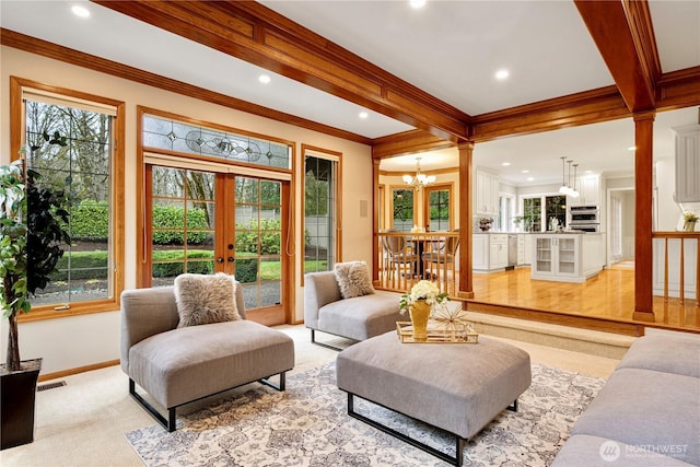 living area featuring a wealth of natural light, visible vents, beamed ceiling, and french doors