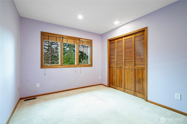 unfurnished bedroom with carpet flooring, baseboards, and visible vents