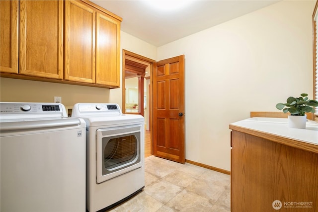 laundry room with washer and dryer, baseboards, and cabinet space