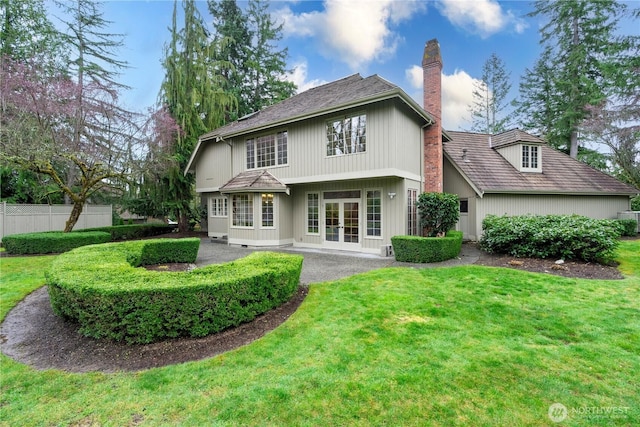 rear view of property with a patio, fence, french doors, a yard, and a chimney