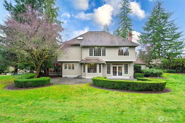 back of house with a patio area, french doors, a chimney, and a yard