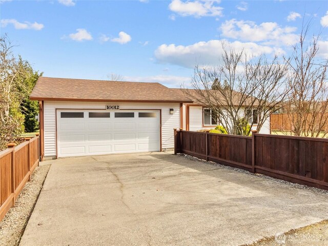 garage with driveway and fence