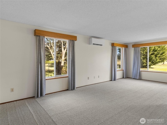 spare room featuring a textured ceiling, a healthy amount of sunlight, carpet flooring, and a wall unit AC