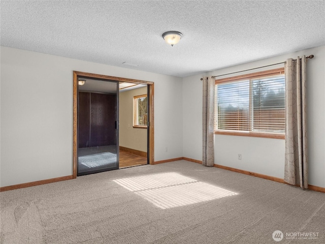 unfurnished bedroom with baseboards, a textured ceiling, and carpet floors