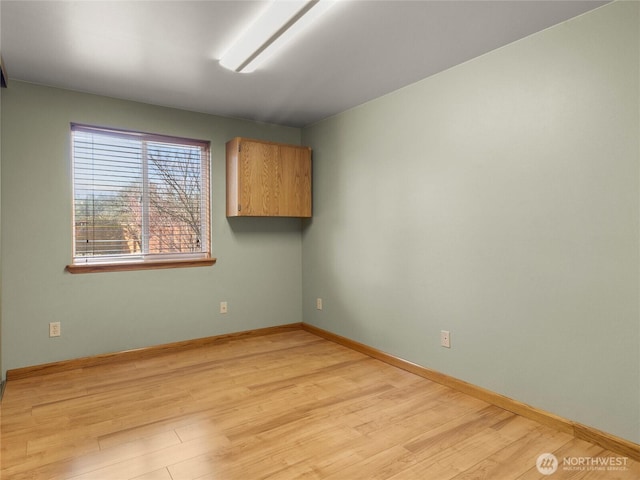 empty room featuring baseboards and light wood-style floors