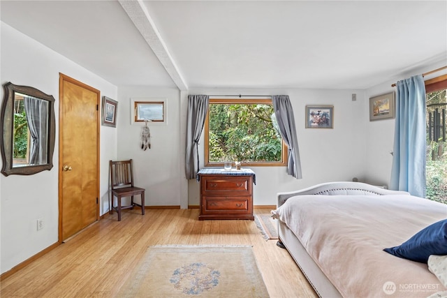 bedroom featuring light wood finished floors and baseboards