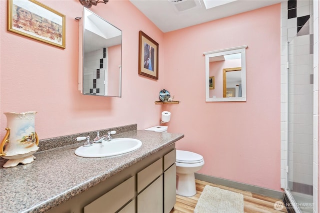 full bathroom featuring visible vents, toilet, vanity, wood finished floors, and tiled shower