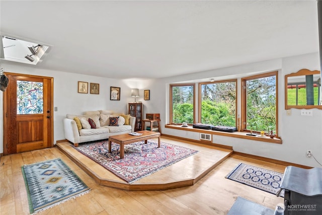 living area featuring hardwood / wood-style floors, visible vents, and baseboards