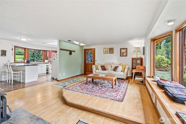 living room with light wood-type flooring and baseboards