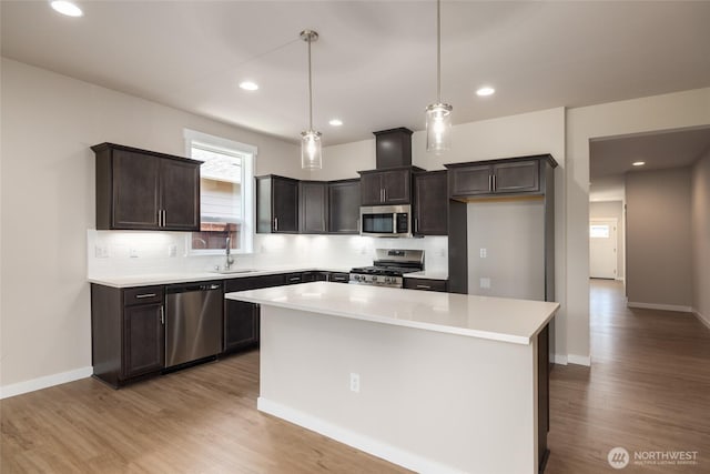 776 Parkland Loop, Sedro Woolley, WA 98284 - kitchen with stainless steel appliances, a sink, dark brown cabinetry, tasteful backsplash, and light wood finished floors