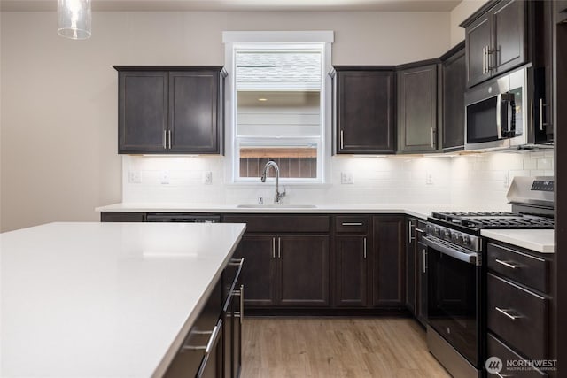 776 Parkland Loop, Sedro Woolley, WA 98284 - kitchen featuring appliances with stainless steel finishes, a sink, light wood-style flooring, and backsplash