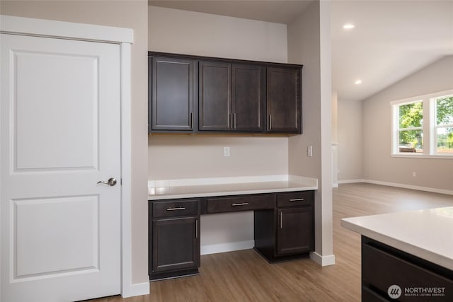 776 Parkland Loop, Sedro Woolley, WA 98284 - kitchen with light wood-style flooring, light countertops, dark brown cabinetry, vaulted ceiling, and baseboards