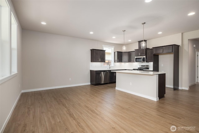 776 Parkland Loop, Sedro Woolley, WA 98284 - kitchen featuring stainless steel appliances, dark brown cabinetry, light countertops, light wood finished floors, and recessed lighting