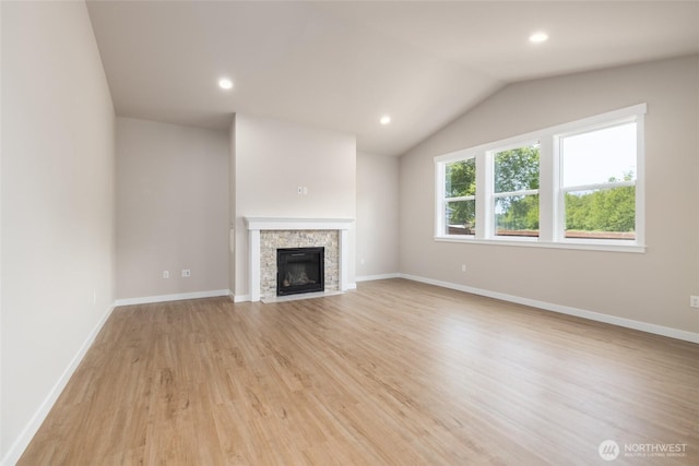 776 Parkland Loop, Sedro Woolley, WA 98284 - unfurnished living room with light wood-style floors, vaulted ceiling, a stone fireplace, baseboards, and recessed lighting