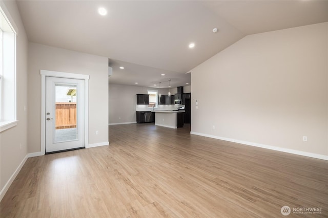 776 Parkland Loop, Sedro Woolley, WA 98284 - unfurnished living room with light wood-style floors, recessed lighting, lofted ceiling, and baseboards