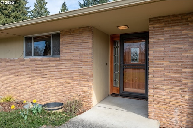 doorway to property with brick siding