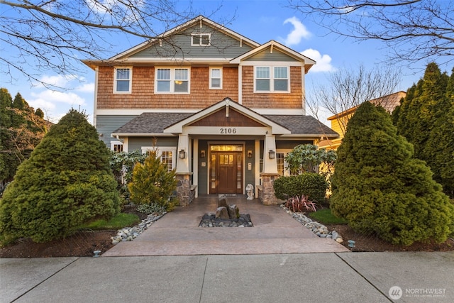 view of front facade featuring concrete driveway and a shingled roof