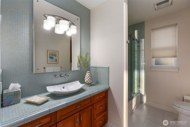 bathroom featuring tile patterned flooring, visible vents, toilet, decorative backsplash, and vanity