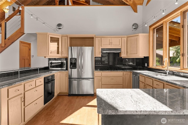 50 Sage Canyon Dr, Winthrop, WA 98862 - kitchen with black appliances, under cabinet range hood, light brown cabinets, light wood-style flooring, and glass insert cabinets