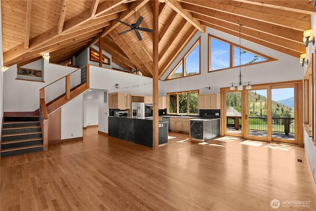 50 Sage Canyon Dr, Winthrop, WA 98862 - unfurnished living room featuring high vaulted ceiling, a wooden ceiling with exposed beams, wood finished floors, stairs, and a mountain view