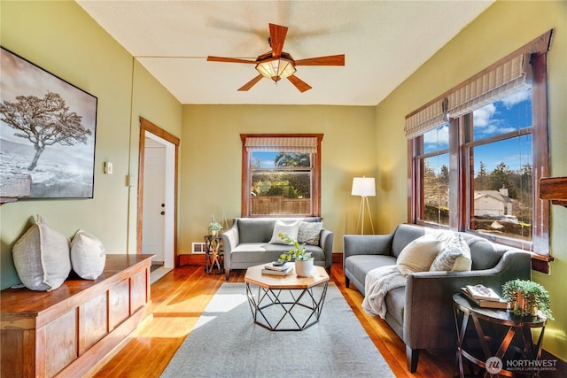 living area with visible vents, wood finished floors, and a ceiling fan