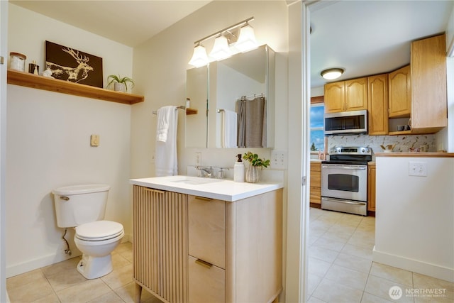 bathroom with tasteful backsplash, tile patterned floors, toilet, and vanity