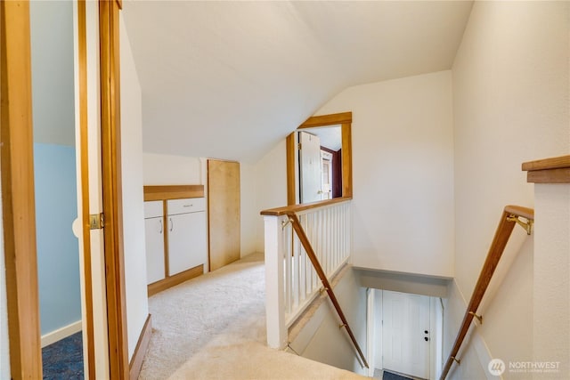 stairs with lofted ceiling and carpet