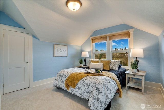 carpeted bedroom with baseboards and vaulted ceiling