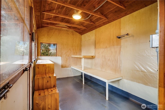 misc room with lofted ceiling, concrete floors, and wooden ceiling