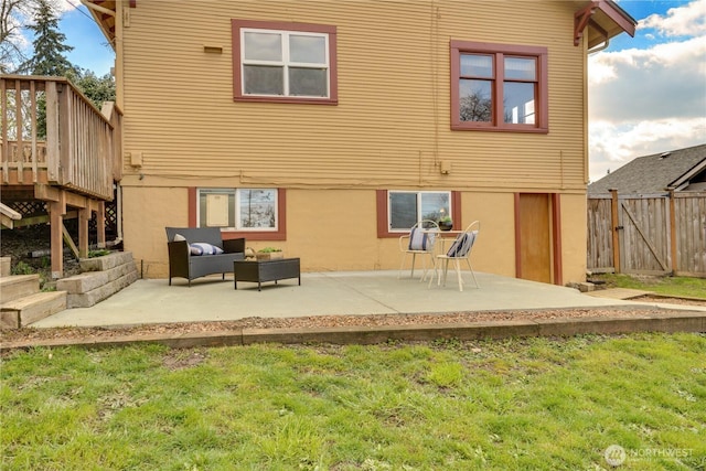 rear view of property with stucco siding, fence, outdoor lounge area, and a patio area