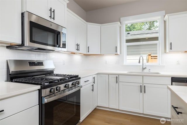 804 Parkland Loop, Sedro Woolley, WA 98284 - kitchen featuring appliances with stainless steel finishes, a sink, white cabinetry, light countertops, and tasteful backsplash