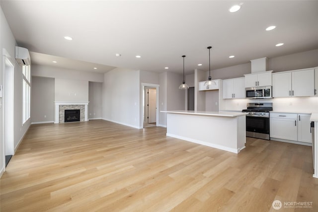 804 Parkland Loop, Sedro Woolley, WA 98284 - kitchen with stainless steel appliances, a wall mounted air conditioner, open floor plan, recessed lighting, and white cabinets