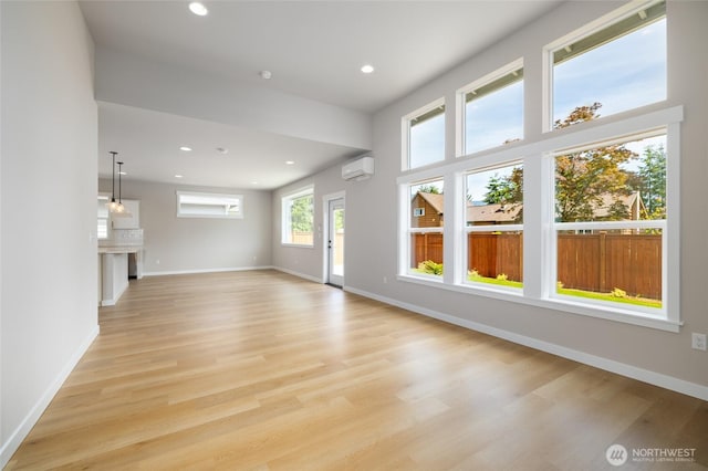 804 Parkland Loop, Sedro Woolley, WA 98284 - unfurnished living room featuring a wall mounted air conditioner, light wood-style flooring, recessed lighting, and baseboards