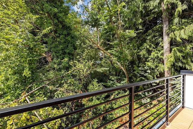 balcony featuring a wooded view