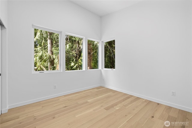 spare room featuring light wood-type flooring and baseboards