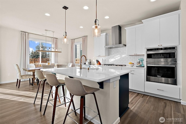 15132 Tyee Dr E, Bonney Lake, WA 98391 - kitchen with backsplash, wall chimney range hood, stainless steel double oven, gas stovetop, and a sink