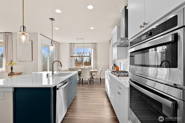 15132 Tyee Dr E, Bonney Lake, WA 98391 - kitchen featuring a sink, tasteful backsplash, stainless steel appliances, wall chimney exhaust hood, and light countertops