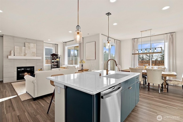 15132 Tyee Dr E, Bonney Lake, WA 98391 - kitchen with stainless steel dishwasher, wood finished floors, a tile fireplace, and a sink