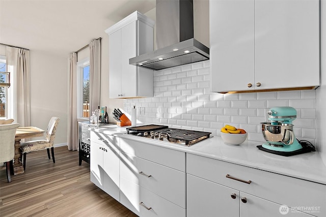 15132 Tyee Dr E, Bonney Lake, WA 98391 - kitchen featuring stainless steel gas cooktop, a healthy amount of sunlight, wall chimney exhaust hood, and light countertops