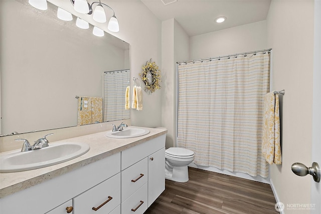 15132 Tyee Dr E, Bonney Lake, WA 98391 - bathroom featuring double vanity, toilet, wood finished floors, and a sink