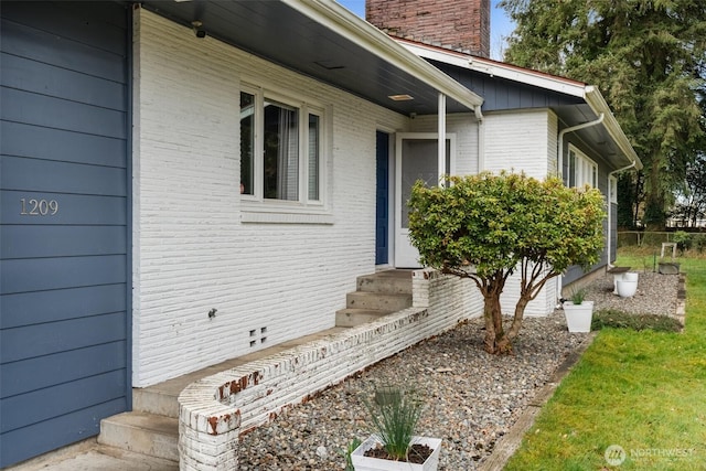 doorway to property with brick siding