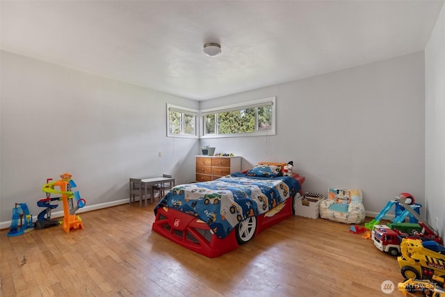 bedroom with hardwood / wood-style flooring and baseboards