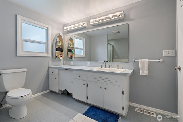 full bath featuring visible vents, baseboards, toilet, vanity, and a shower