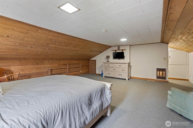 bedroom with wooden walls, heating unit, carpet, baseboards, and lofted ceiling